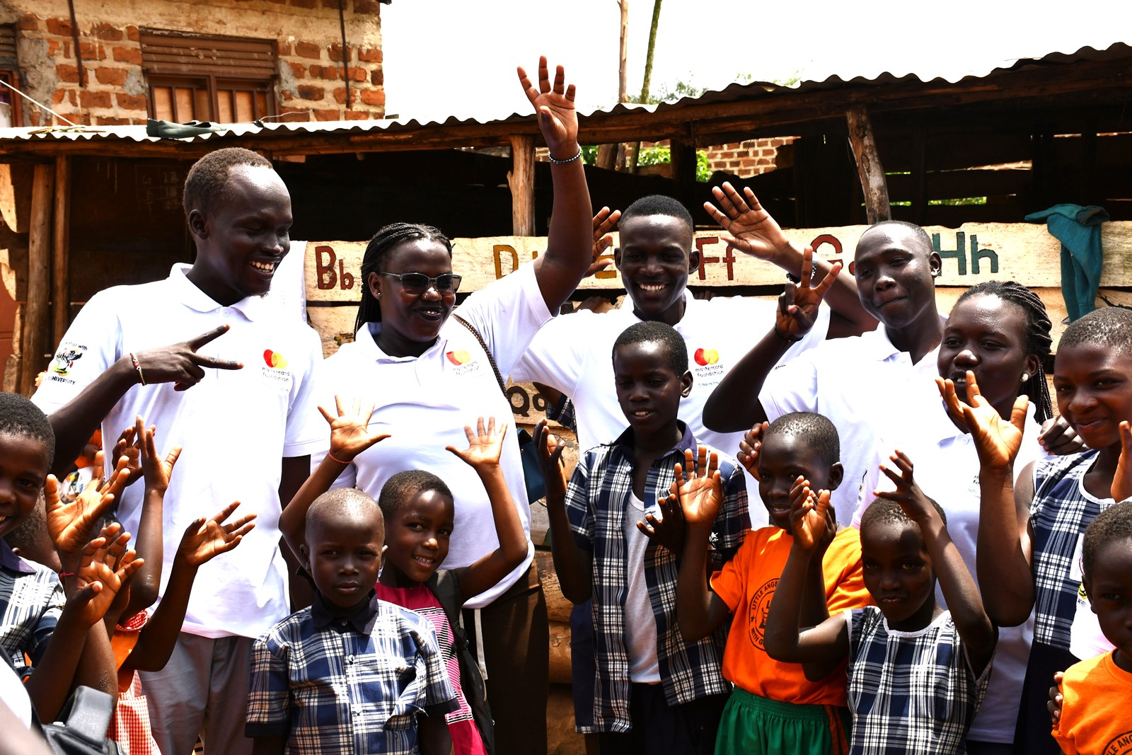 A cross-section of Mastercard Foundation Scholars pose in a photograph with pupils of Little Angels Primary School. Mastercard Foundation Scholars at Makerere University, Kampala during the Annual Scholars Day of Community Service at Little Angels Nursery and Primary School in Ntenjeru, Mukono District, and St. Charles Rwahunga, Nursery and Primary School in Kyegegwa District, Uganda, East Africa, 16th November 2024.