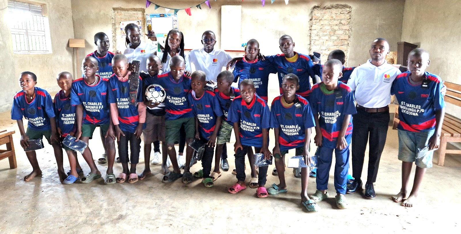 The boys' football team of St. Charles Rwahunga Primary School pose in a photo after receiving the sports wear donated by the Scholars of Mastercard Foundation. Mastercard Foundation Scholars at Makerere University, Kampala during the Annual Scholars Day of Community Service at Little Angels Nursery and Primary School in Ntenjeru, Mukono District, and St. Charles Rwahunga, Nursery and Primary School in Kyegegwa District, Uganda, East Africa, 16th November 2024.