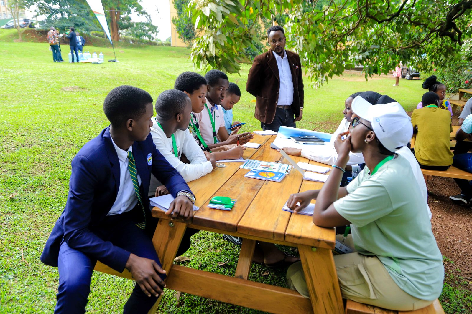 Dr. Gardner Rwakiseta (standing) listens in on the group discussions. The Julius Nyerere Leadership Center (JNLC) transformative three-day Youth Leadership Training program for secondary school student leaders, December 2024 Makerere University, Kampala Uganda, East Africa.