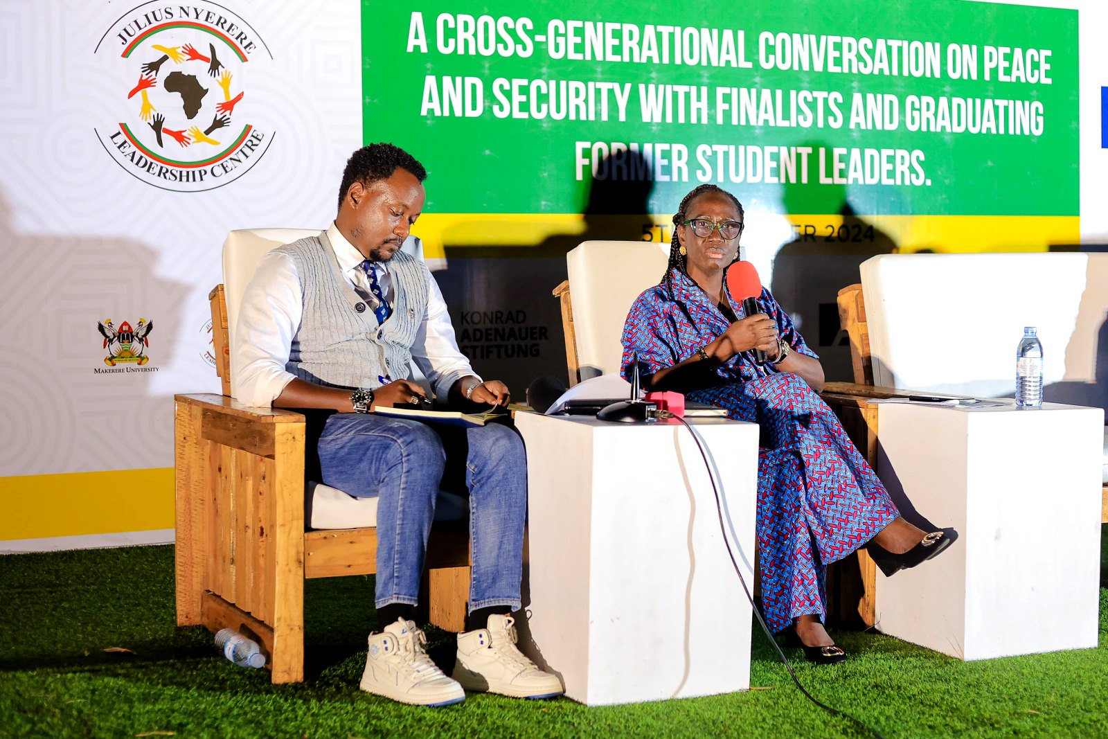 Ms. Falade Olutoyin (Right) contributes to the discussion as the Moderator Dr. Gardner H. Rwakiseta (Left) follows proceedings. Konrad Adenauer Stiftung-Julius Nyerere Leadership Centre (JNLC) Peace and Security Leadership Training for Finalists and Graduating former Student Leaders in Different Universities in Uganda, Day Three, 5th December 2024, JNLC Gardens, Pool Road, Makerere University, Kampala Uganda, East Africa.