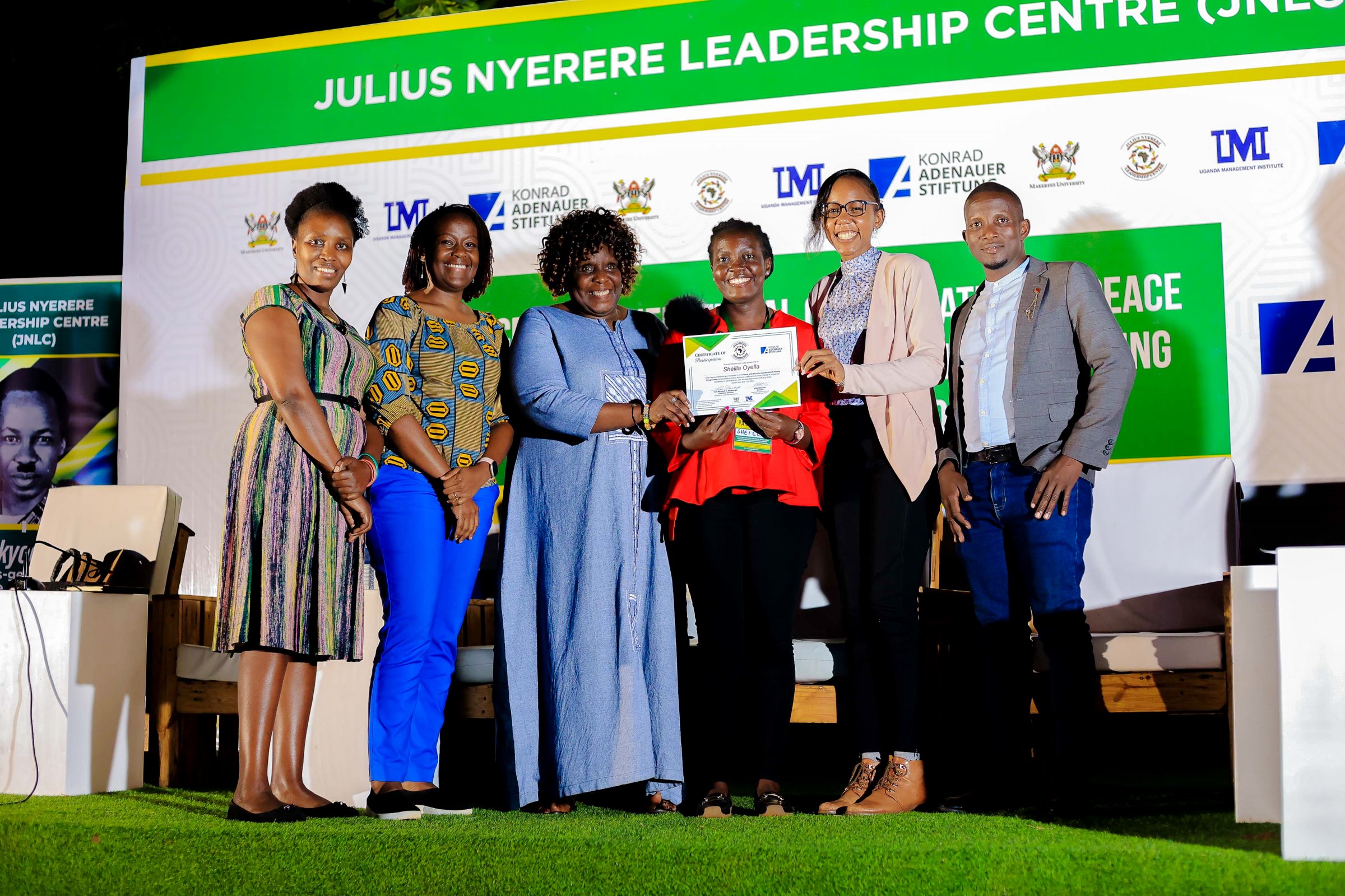 Dr. Nansozi Muwanga (3rd Left) and Ms. Angella Kasekende (2nd Right) together with other officials present a certificate to one of the female Student Leaders - Sheilla Oyella on 5th November 2024. Konrad Adenauer Stiftung-Julius Nyerere Leadership Centre (JNLC) Peace and Security Leadership Training for Finalists and Graduating former Student Leaders in Different Universities in Uganda, Day Three, 5th December 2024, JNLC Gardens, Pool Road, Makerere University, Kampala Uganda, East Africa.