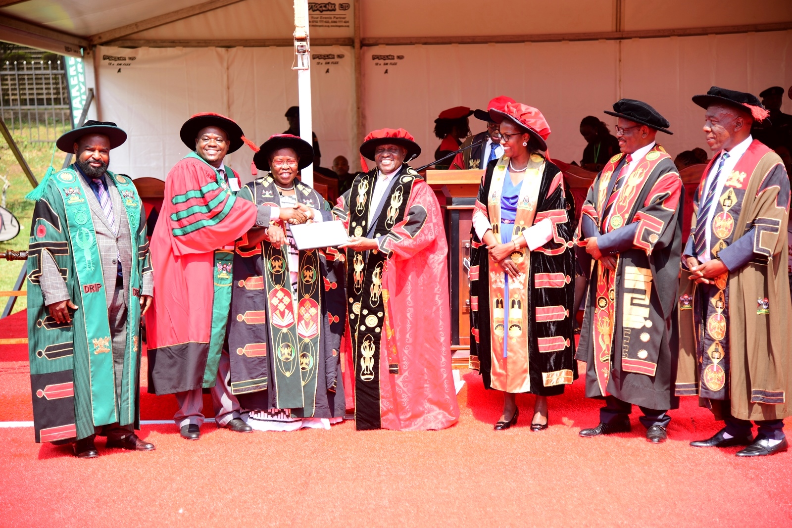 Hon. Dr. Crispus Kiyonga (C) and Hon. Dr. Joyce Moriku Kaducu (3rd L) present the Research Excellence Award to Prof. Mugisha Lawrence from the College of Veterinary Medicine, Animal Resources and Biosecurity (CoVAB) (2nd L). 75th Graduation Ceremony, Day 1, CoCIS, CEES, CoVAB and School of Law. 13th January 2025, Freedom Square, Makerere University, Kampala Uganda, East Africa.