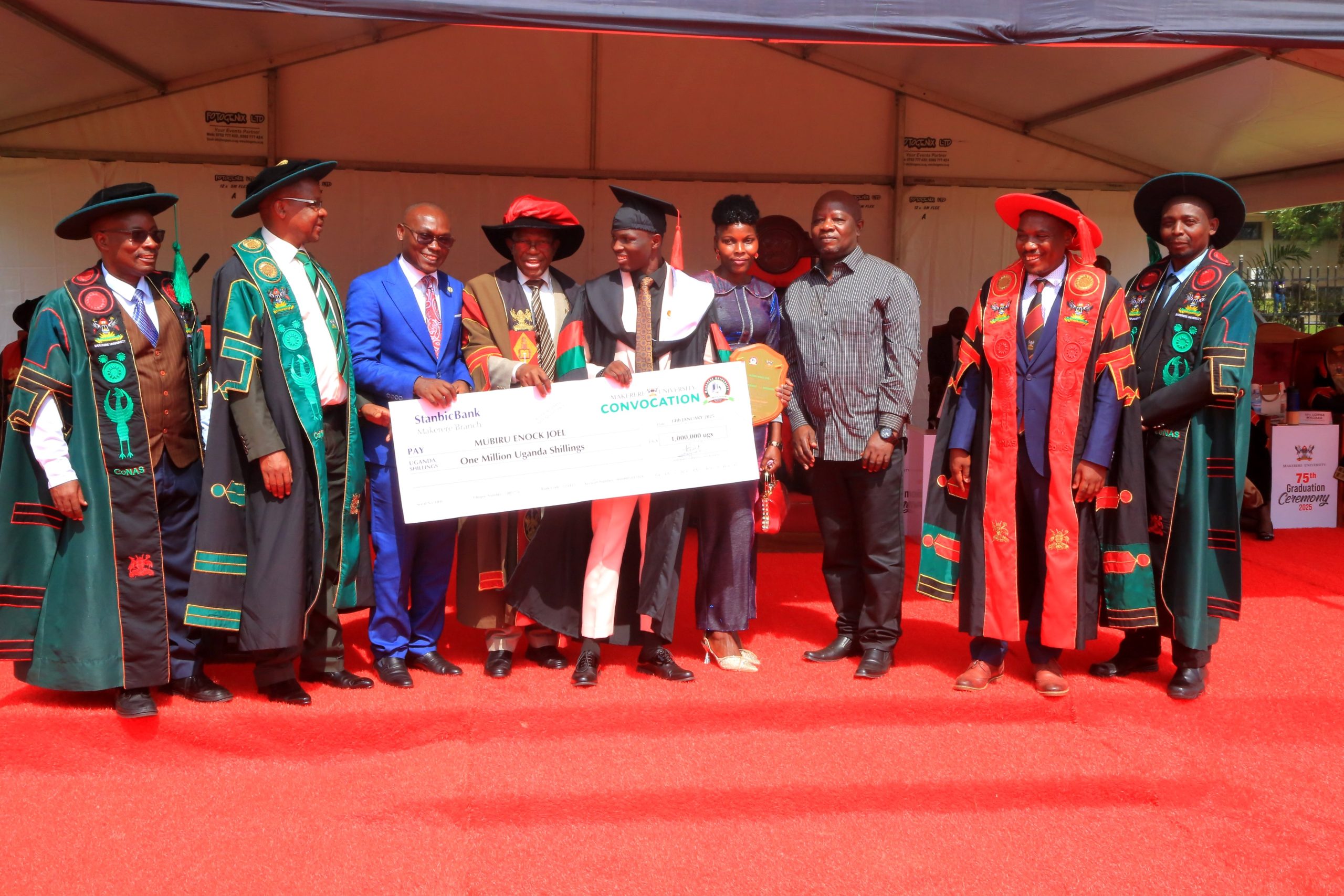 AR-Prof. Buyinza Mukadasi (4th L) and Chair Convocation-Mr. George Turyamureeba (3rd L) present the Award to Mubiru (C) as his parents (3rd & 4th R) as well as CoNAS Principal-Prof. Winston Tumps Ireeta (2nd R) and College Leadership witness. 75th Graduation Ceremony, Day 2, CoBAMS, CHS and CoNAS. 14th January 2025, Freedom Square, Makerere University, Kampala Uganda, East Africa.