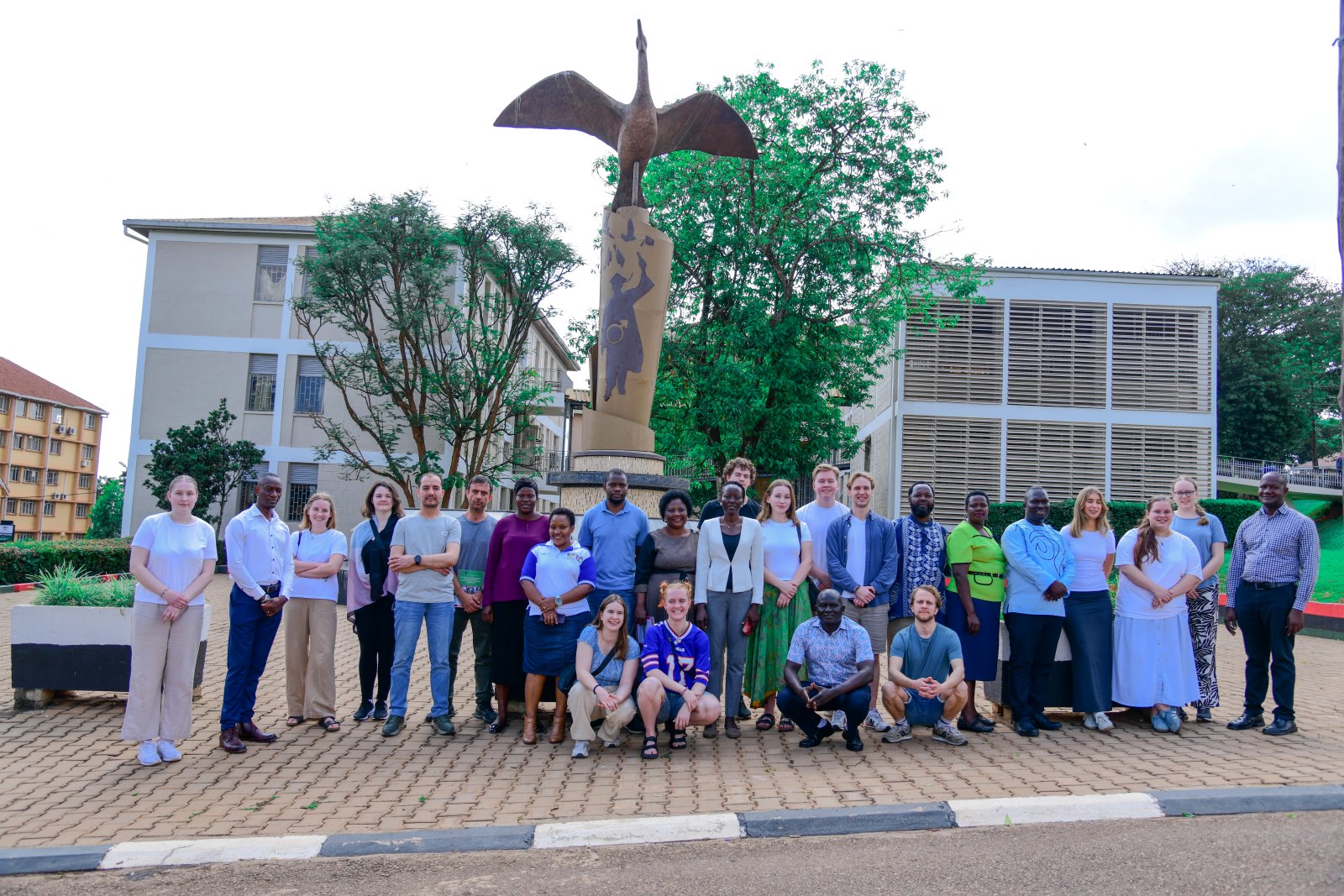 Dr. Harriet Nabushawo, Dr. Joseph Watuleke, Ms. Nuluyati Nalwadda, Dr. Stella Achen and Dr. Oscar Mugula pose for a group photo with the exchange students at the Makerere@100 Statue. Department of Adult and Community Education, School of Distance and Lifelong Learning, College of Education and External Studies (CEES) hosting 17 exchange students from the University of Agder, Norway, as part of a one-month field course. Induction January 6th, 2025, Main Building, Makerere University, Kampala Uganda, East Africa.