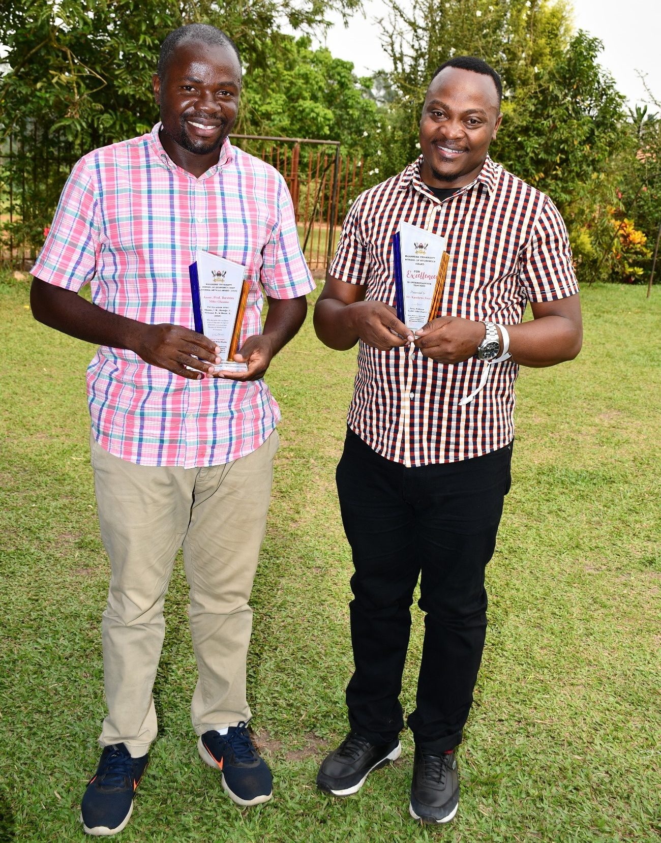 Prof. Ibrahim Mike Okumu (L) and Mr. Fredrick Kasalirwe (R) pose with their Academic Excellence and Best Teaching Awards respectively. School of Economics, College of Business and Management Sciences (CoBAMS), Makerere University, Kampala team-building activity, 15th January 2025, Buwatte, Wakiso, Uganda, East Africa.