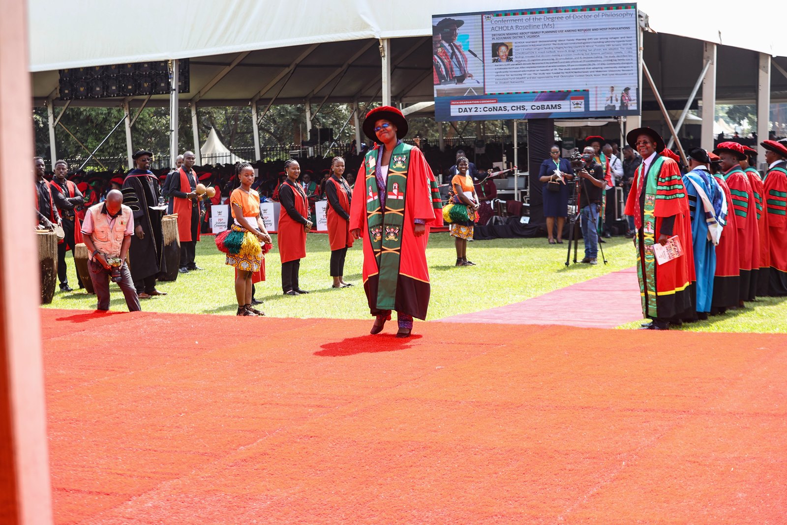 Ms. Roselline Achola walking majestically to receive her PhD award from the Chancellor on Graduation day. 75th Graduation Ceremony, Day 2, CoBAMS, CHS and CoNAS. 14th January 2025, Freedom Square, Makerere University, Kampala Uganda, East Africa.