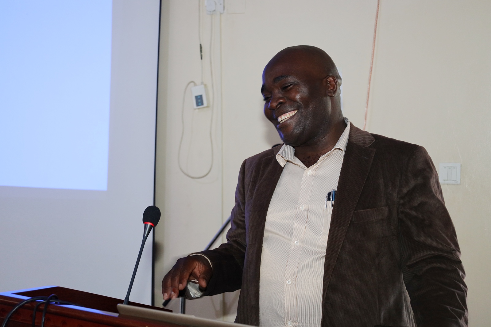 Dr. John Sseruyange reacts during his remarks. Public Investment Management (PIM) Centre of Excellence, College of Business and Management Sciences (CoBAMS), Makerere University, Kampala, Day 1 of three-day refresher training for members of the Development Committee (DC) of the Ministry of Finance, Planning and Economic Development, 19th February 2024, Jinja Uganda, East Africa.