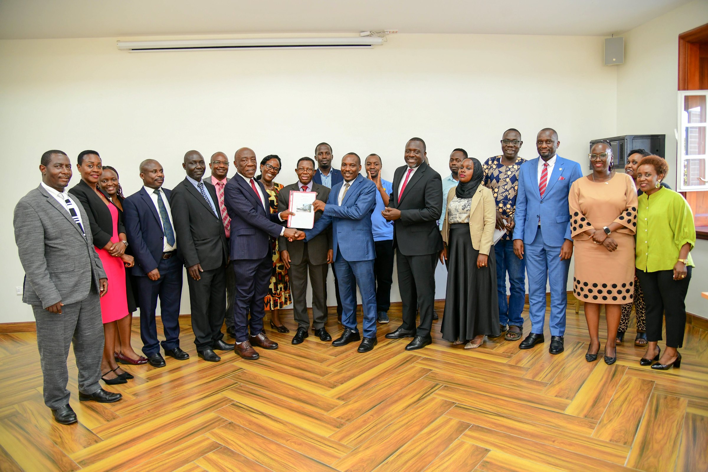 Prof. Buyinza Mukadasi (C), Members of Management and Staff witness as Prof. Henry Alinaitwe presents a copy of his handover report to Prof. Winston Tumps Ireeta. Prof. Henry Alinaitwe officially hands over Office of Deputy Vice Chancellor (Finance and Administration)-DVCFA to Prof. Winston Tumps Ireeta, 20th February 2025, Main Building, Makerere University, Kampala Uganda, East Africa.