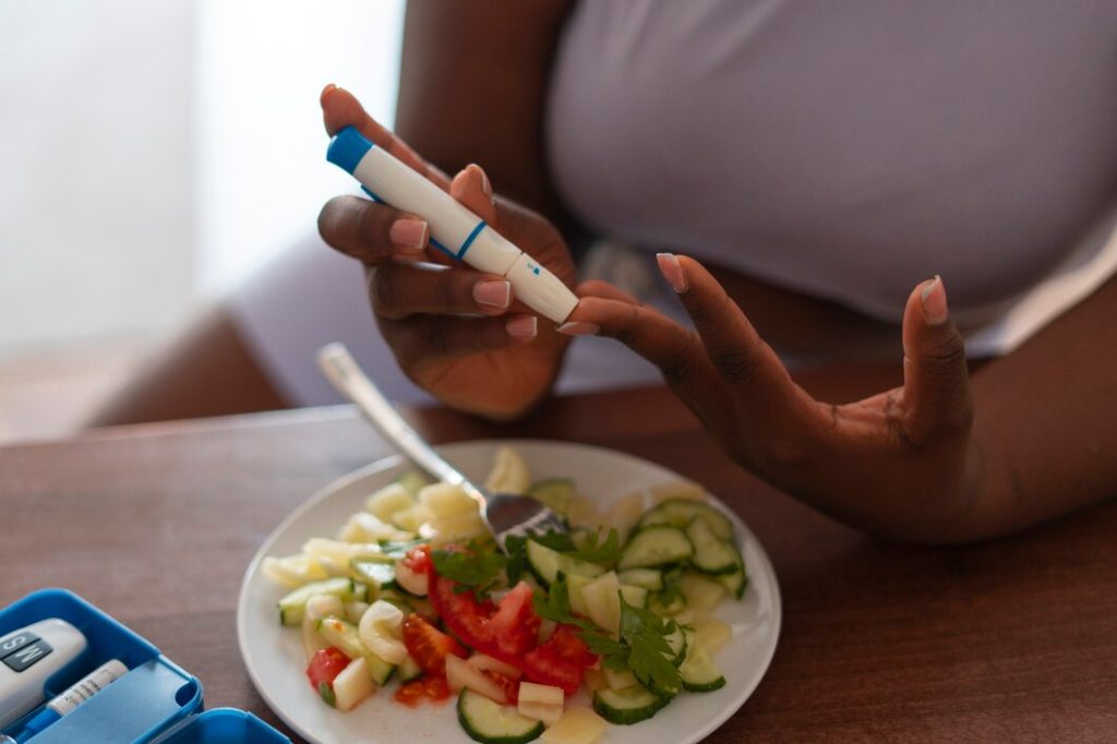 High angle woman checking glucose levels. Photo courtesy of Freepik. Makerere University School of Public Health (MakSPH), Kampala Uganda, East Africa.