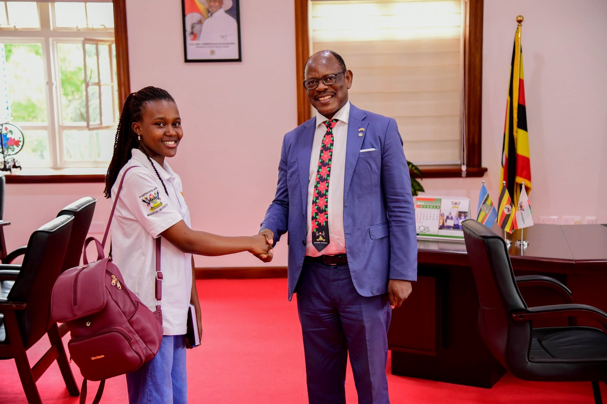 Prof. Barnabas Nawangwe (Left) shakes hands with Elizabeth Gabeya during the role play. 21-year-old Elizabeth Gabeya, a Bachelor of Agricultural and Rural Innovation First Year Mastercard Foundation Scholar at Makerere University, takes charge of the Vice Chancellor's office for two days- March 10th and 11th 2025, Main Building, Kampala Uganda, East Africa.