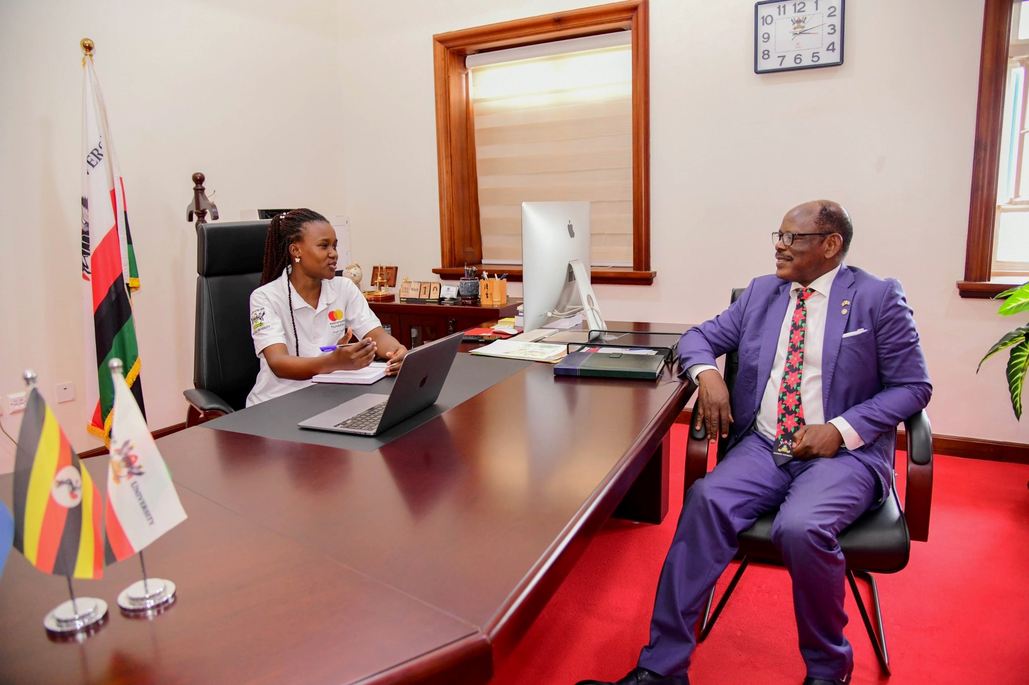 Prof. Barnabas Nawangwe (Right) listens to Elizabeth Gabeya (seated at his desk) during the unforgettable experience. 21-year-old Elizabeth Gabeya, a Bachelor of Agricultural and Rural Innovation First Year Mastercard Foundation Scholar at Makerere University, takes charge of the Vice Chancellor's office for two days- March 10th and 11th 2025, Main Building, Kampala Uganda, East Africa.