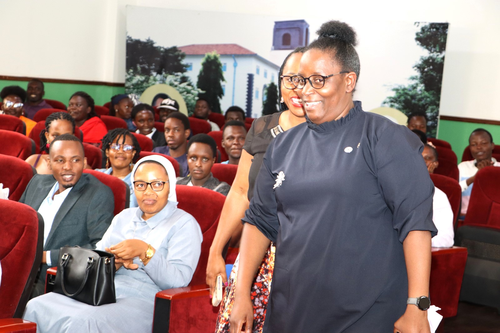 Prof. Helen Nambalirwa Nkabala being ushered in by Dr. Cindy Magara. Department of Literature, School of Languages, Literature and Communication, College of Humanities and Social Sciences (CHUSS) screening of Tuko Pamoja, a documentary by Dr. Cindy Magara, Nyati Motion Pictures, 13th May 2025, Main Hall, Makerere University, Kamapala Uganda, East Africa.