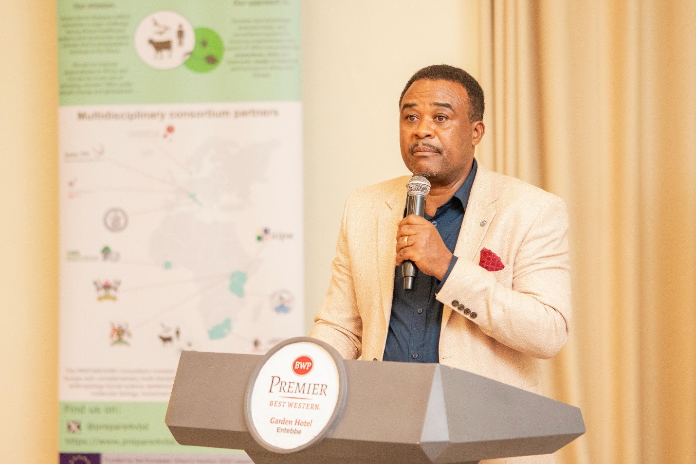 Dr. Allan Muruta, Guest of Honour and Commissioner for Animal Health Services at the Ministry of Health sharing his remarks. Final dissemination workshop of the EU-funded project: A Cross-Disciplinary Alliance to Identify, PREdict, and PrePARe for Emerging Vector-Borne Diseases (PREPARE4VBDs) with Prof. Lawrence Mugisha Co-Principal Investigator from College of Veterinary Medicine, Animal Resources and Biosecurity (CoVAB), Makerere University, held 5th-8th May 2025, Best Western Premier Garden Hotel, Entebbe, Uganda, East Africa.