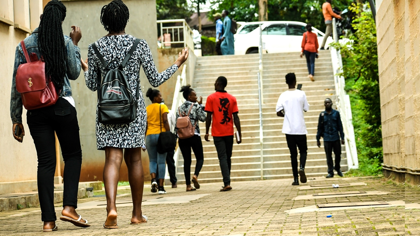 Students stroll past the Frank Kalimuzo Central Teaching Facility-CTF (Left) and School of Social Sciences (Right) on the Makerere University Main Campus. Staircase, Walkway, Male, Female, Kampala Uganda, East Africa.