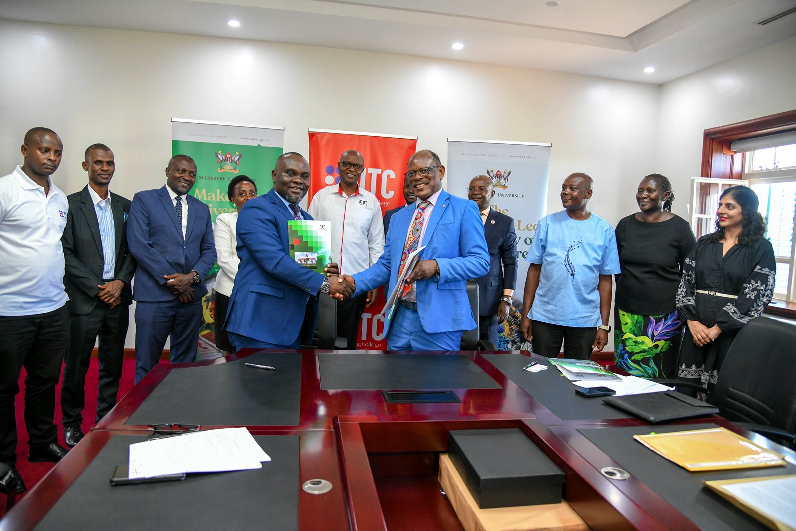 Prof. Barnabas Nawangwe and Mr. Saul Sseremba exchange the signed MoU. Makerere University signs Memorandum of Understanding (MoU) with the Insurance Training College (ITC) to be implemented through the College of Business and Management Sciences (CoBAMS) aimed at enhancing professional training, research, and industry engagement in the fields of actuarial science and insurance, 6th May 2025, Main Building, Makerere University, Kampala Uganda, East Africa.