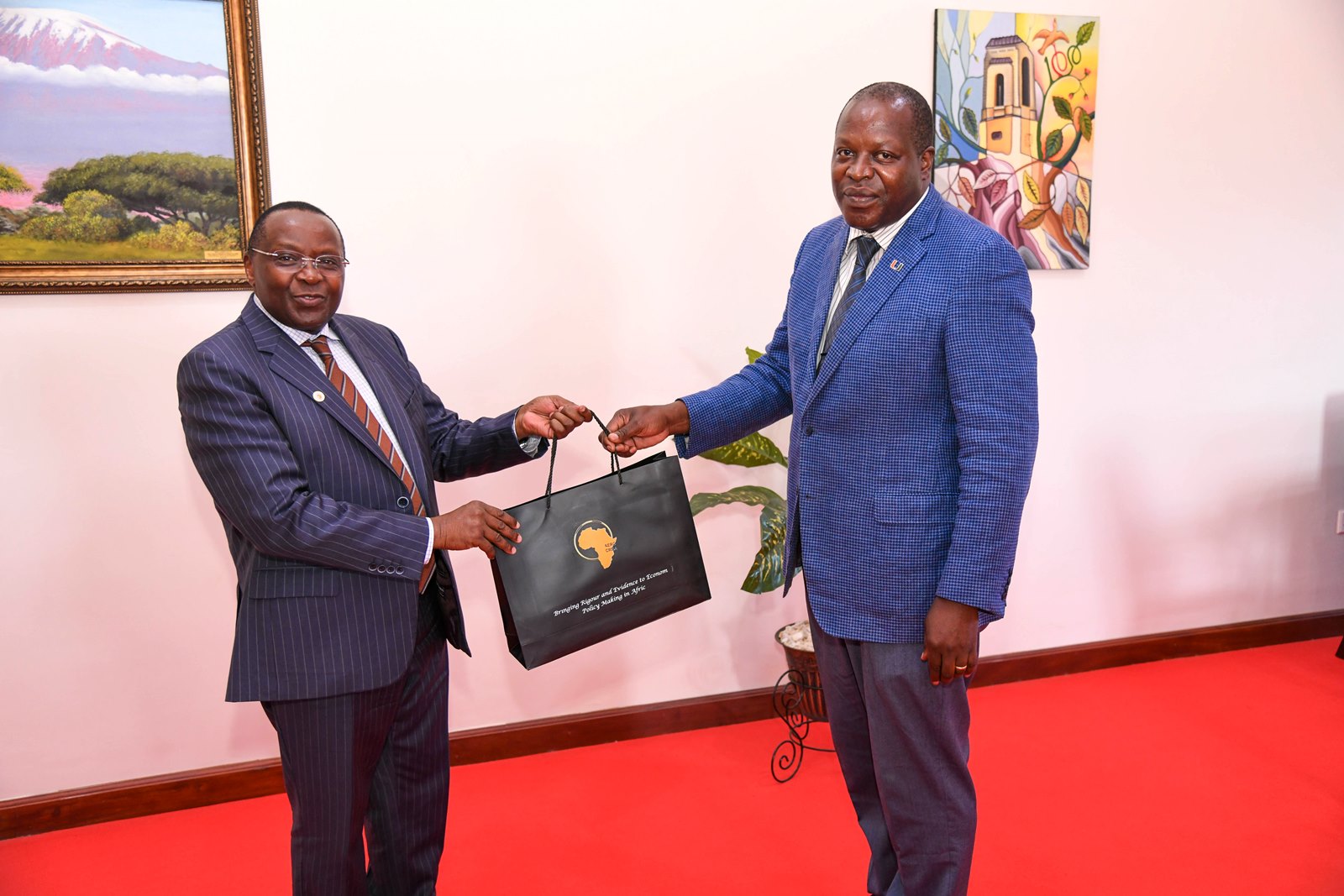 Prof. Victor Murinde (Left) presents an AERC souvenir to Prof. Tonny Oyana. Delegation from the African Economic Research Consortium (AERC) courtesy call on the Vice Chancellor, received by Prof. Tonny Oyana, 23rd May 2025, Makerere University, Kampala Uganda.