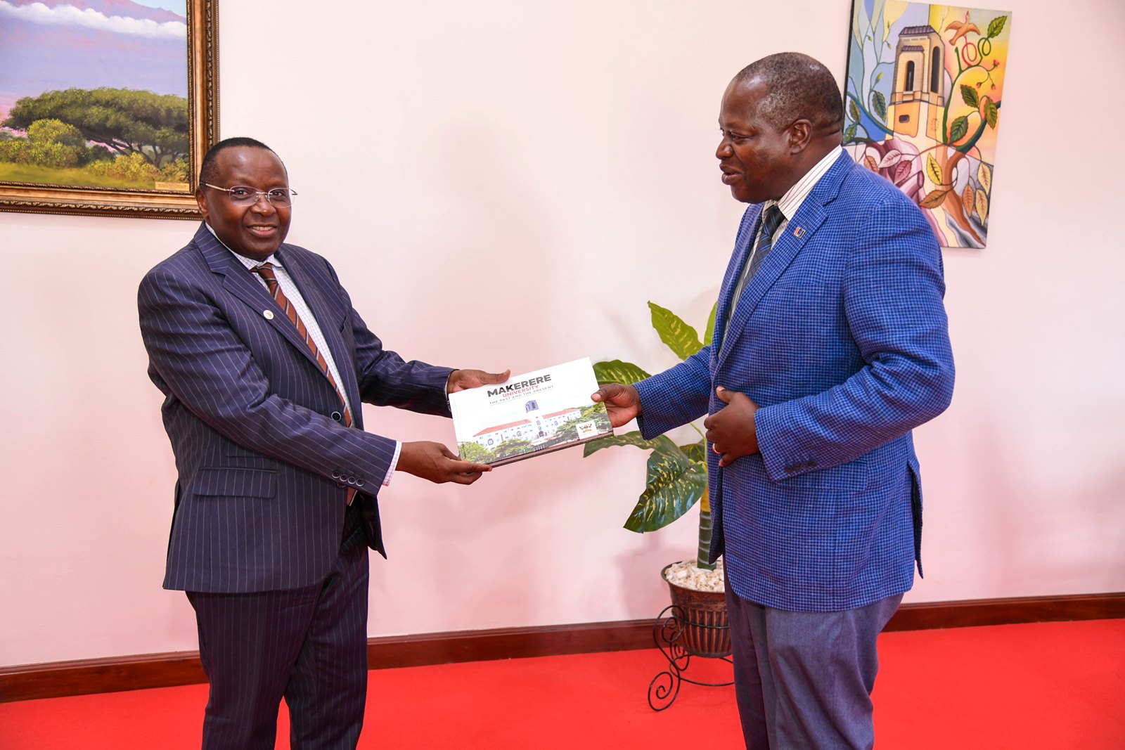 Prof. Tonny Oyana (Right) presents the Makerere Souvenir Book to Prof. Victor Murinde. Delegation from the African Economic Research Consortium (AERC) courtesy call on the Vice Chancellor, received by Prof. Tonny Oyana, 23rd May 2025, Makerere University, Kampala Uganda.