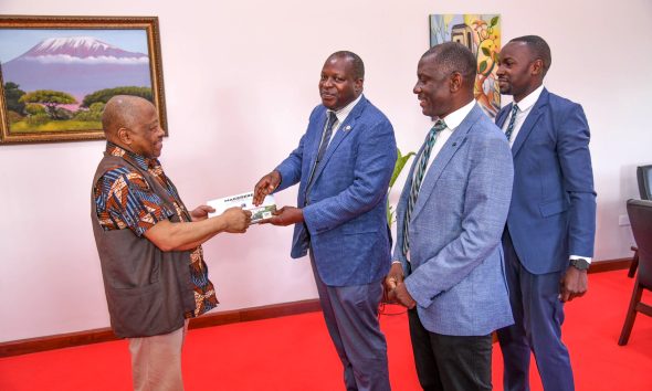 Prof. Omotade Akin Aina (Left) receives the Makerere Souvenir Book from Prof. Tonny Oyana as Prof. Julius Kikooma (2nd Right) and Mr. Charles Lwanga (Right) witness. Prof. Omotade Akin Aina-Carnegie Corporation of New York meeting to discuss progress of Consolidating Early Career Academics Programme (CECAP) phase II, which focuses on fostering academic development and research among early-career academics, 23rd May 2025, Main Building, Makerere University, Kampala Uganda, East Africa.