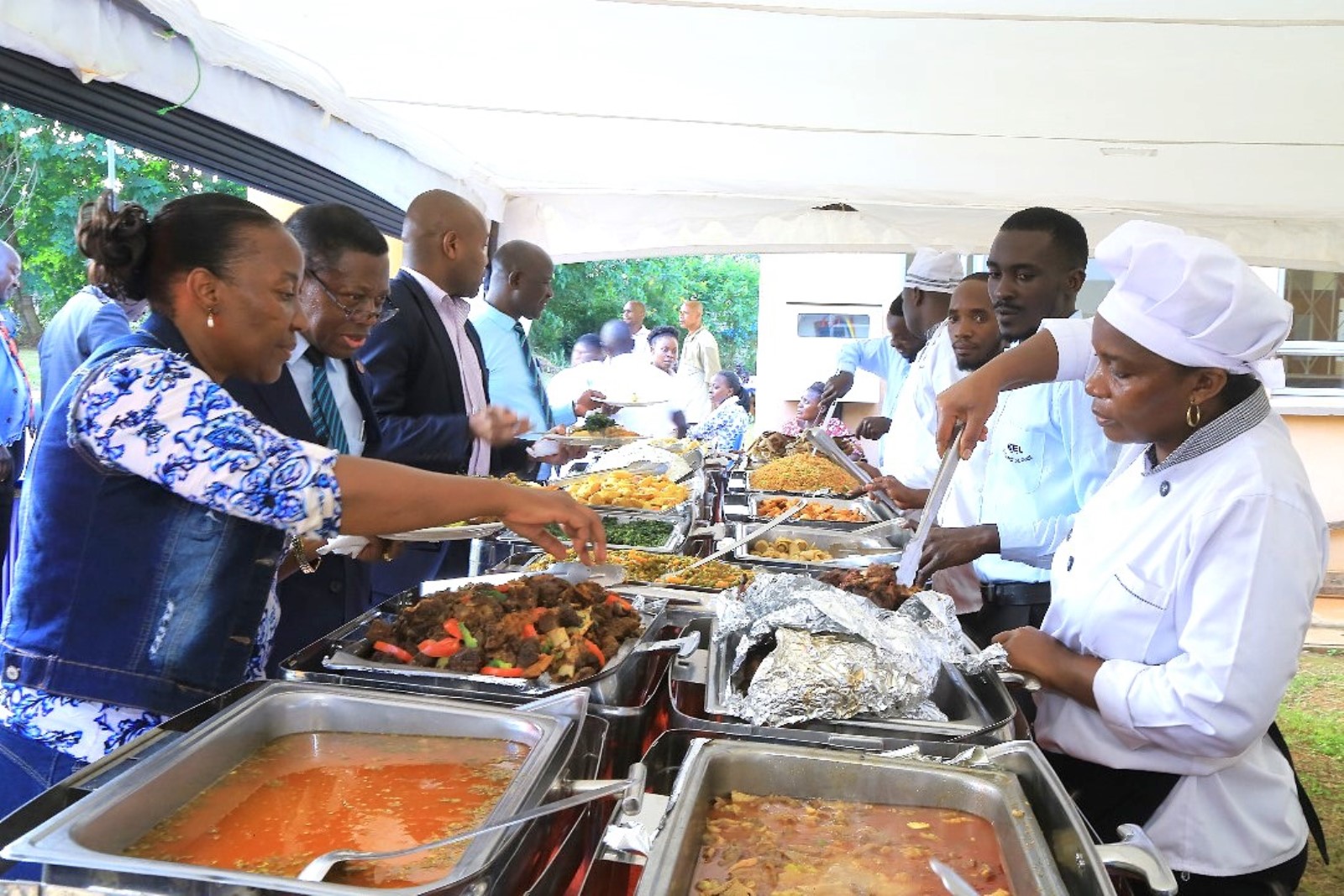 CAES staff led by the DVCAA and the Principal serve the meal. College of Agricultural and Environmental Sciences (CAES) refurbishment of Makerere University Agricultural Research Institute Kabanyolo (MUARIK) Main Gate by students from both CAES and the College of Engineering, Design, Art, and Technology (CEDAT), official opening, 30th May 2025, Wakiso Uganda, East Africa.