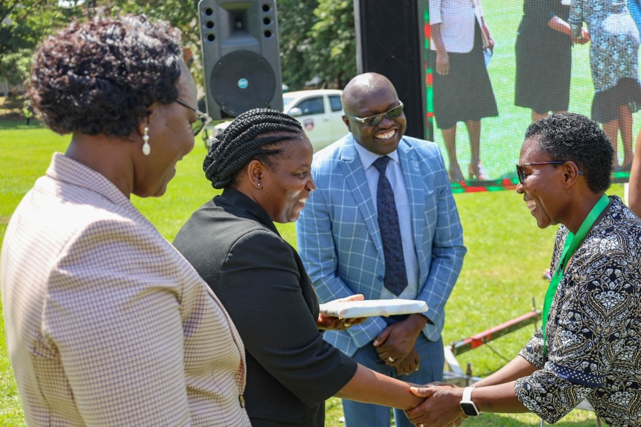 Prof. Helen Nambalirwa Nkabala handing over a gift to a female participant. Science of Designing, Adaptation, and Implementation of Evidence-Based Parenting Interventions 12-week course, Child Health and Development Centre (CHDC), College of Health Sciences (CHS) graduation presided over by The Iteso Cultural Leader, His Highness Emorimor Papa Paul Sande Emolot, 11th June 2025, Freedom Square, Makerere University, Kampala Uganda, East Africa.