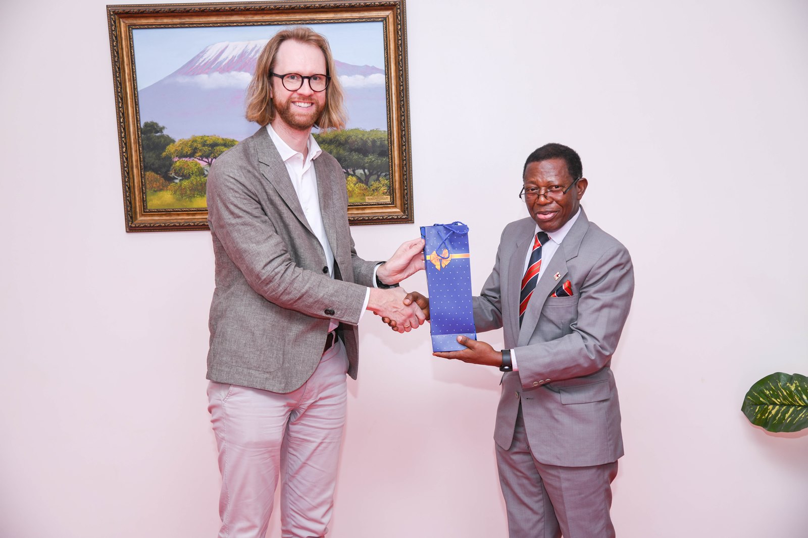 Prof. Buyinza Mukadasi (R) presents a souvenir to Prof. Muller Gustavo (L). Network on Europe and Africa Relations-Education and Research (NEAR-ER) project, a Jean Monnet policy network of 20 higher education institutions; 7 in Europe and 13 in Africa, Dialogue targeting early career researchers and graduate students organized by School of Statistics, College of Business and Management Sciences (CoBAMS), 16th June 2025, Main Hall, Makerere University, Kampala Uganda, East Africa.
