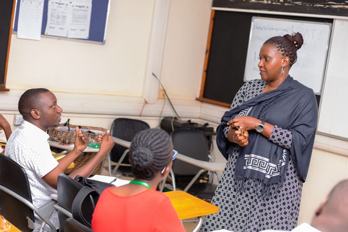 Dr. Marjorie Kyomuhendo, one of the course facilitators, engages Mr. Jackson Ssewanyana, a participant in the first cohort of the Certificate in Health Communication and Community Engagement, as Ms. Maureen Kisaakye listens in. June 5, 2025. Intensive one-month course on Health Communication, first cohort June 5 to July 24, 2025, jointly offered by Makerere University School of Public Health (MakSPH)’s Department of Community Health and Behavioural Sciences (CHBS) and the Department of Journalism and Communication (DJC), School of Languages, Literature, and Communication (SLLC), co-designed in 2024 with support from the Rockefeller Foundation through Amref Health Africa, Kampala Uganda, East Africa.