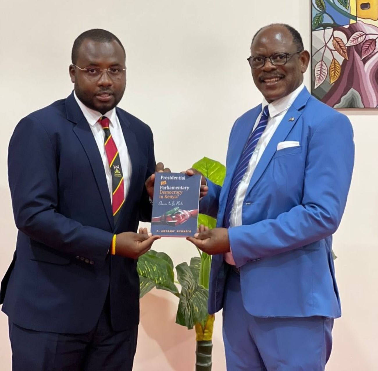 Prof. Barnabas Nawangwe receiving Prof. Anyang' Nyong'o's book from Mr. Katumba Salim