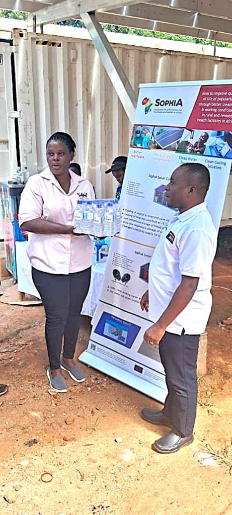 The Co-PI, Dr Sarah Bimbona presents SophiA water to the in-charge of Buvuma Health Centre IV, Dr. Remegio Ndyanabo. European Union-funded Sustainable Off-Grid Solutions for Pharmacies and Hospitals in Africa (SophiA) Project, comprehensive Training of Trainers workshop, June 23 to 27, 2025, Conference Hall, School of Food Technology, Nutrition and Bioengineering (SFTNB), College of Agricultural and Environmental Sciences (CAES), Makerere University, Kampala Uganda, East Africa.