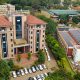 An elevated shot of the IDI-McKinnell Knowledge Centre (Left) and the Department of Pharmacy Building (Right) with the array of solar panels. Vice Chancellor, Prof. Barnabas Nawangwe inaugurated the Infectious Diseases Institute (IDI) at Makerere University's ground-breaking 384kWp solar-powered electricity grid, Africa’s largest campus-based solar system, July 24, 2024, Kampala Uganda, East Africa.