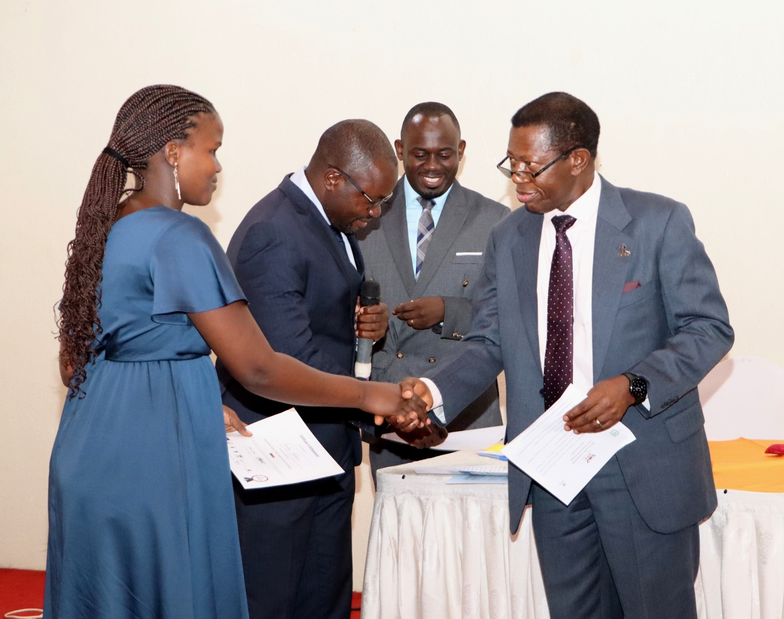 A graduating fellow receiving the certificate from Prof. Buyinza Mukadasi. 4th Cohort of Makerere University Inclusive Green Economy (IGE) Fellows—senior public servants from five key government institutions who completed a year-long training on green economic transformation focusing on reducing emissions in Uganda’s transport sector graduation and introduction of IGE Cohort 2025-2026, Kampala Kolping Hotel, East Africa 2nd July 2025.