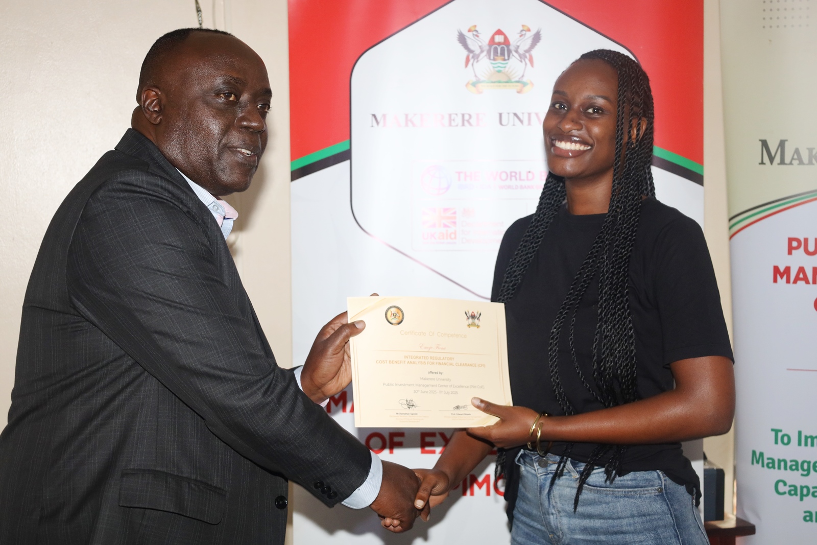 Commissioner Paul Mwanja presents a certificate to a participant. Public Investment Management (PIM) Centre of Excellence at Makerere University College of Business and Management Sciences (CoBAMS) conclusion of two-week training on the Certificate of Financial Implications (CFI) – Integrated Regulatory Cost-Benefit Analysis, for 34 economists from various MDAs with critical policy evaluation and fiscal analysis skills, 11th July 2025, Pearl on the Nile Hotel, Jinja Uganda, East Africa.