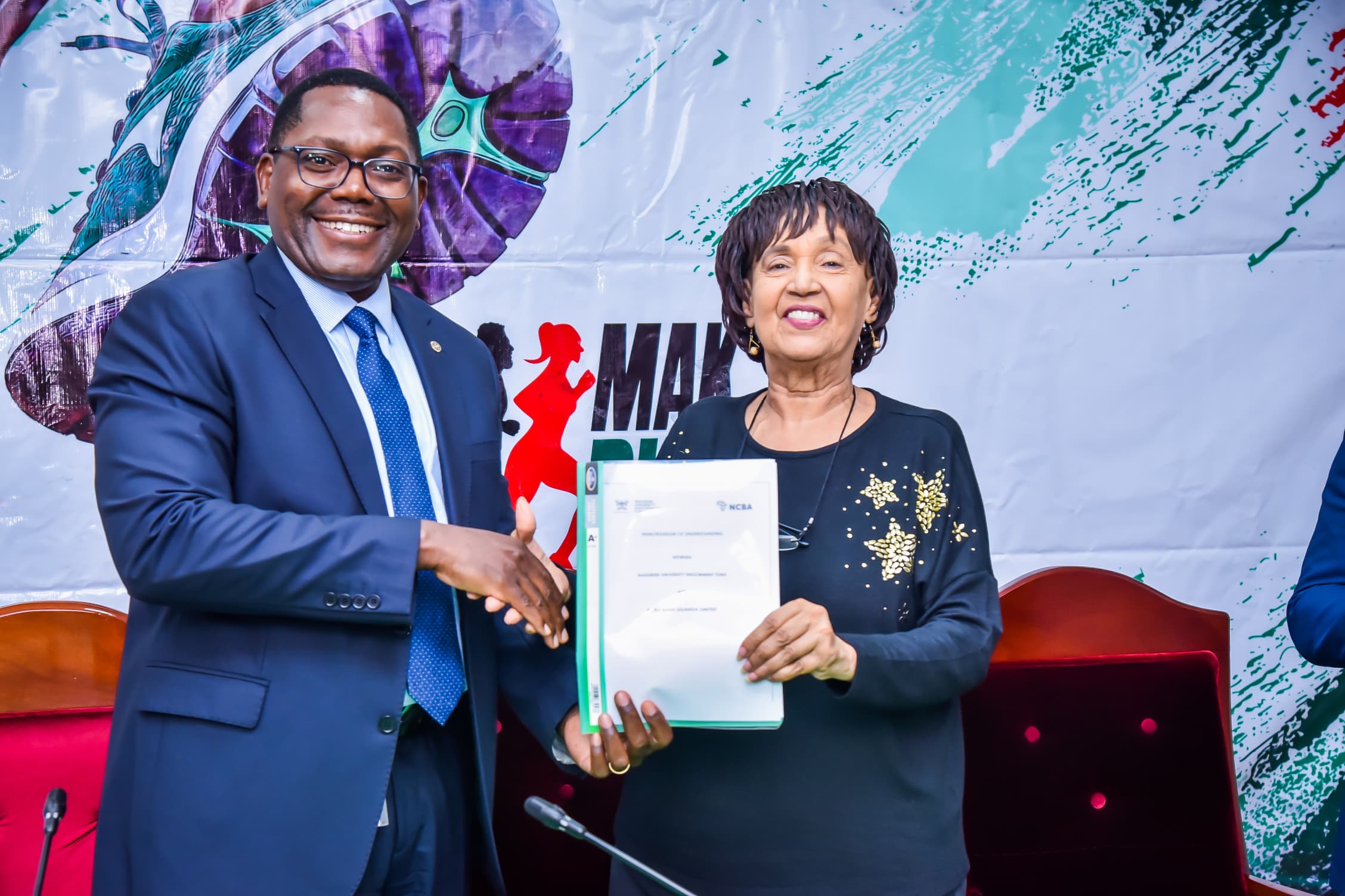 Mr. Mark Muyobo (L) and Dr. Maggie Kigozi (R) pose with the signed MoU. Makerere University Endowment Fund (MakEF)’s flagship initiative – the Makerere University Marathon unveiling of NCBA Bank Uganda as Platinum Sponsor with UGX 1.45 Billion over five years, 9th July 2025, Kampala, East Africa.