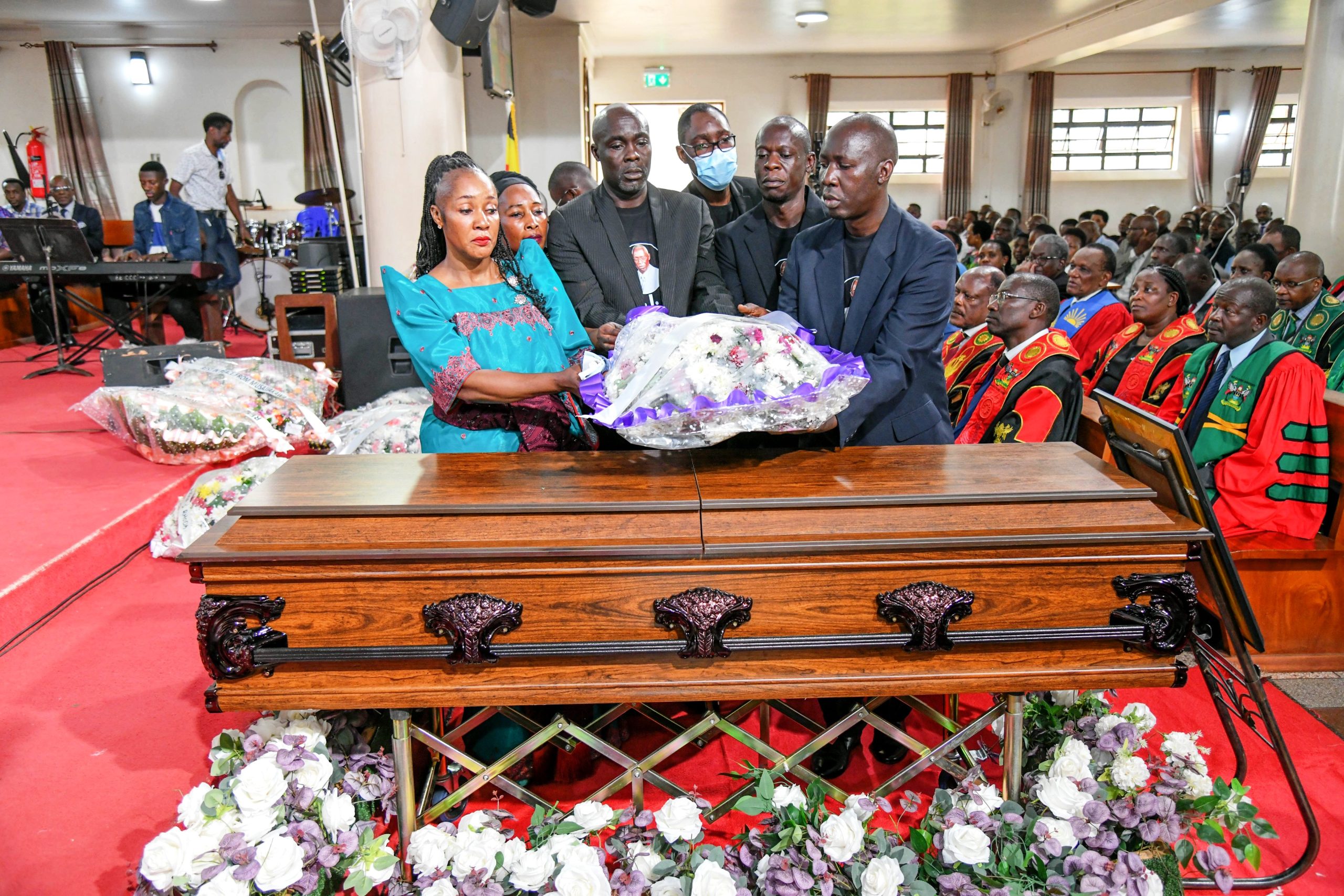 Some of Prof. Luboobi's children Left to Right: Dr. Irene Nakiyimba, Sarah Nantale, James Mazzi Sserwadda, Lazarus Kasobya, Dr. David Kimera, and Prof. Daniel Kibuule lay a wreath on their father's casket. Funeral service in honour of Professor Livingstone Sserwadda Luboobi, 18th July 2025, St. Francis Chapel, Makerere University, Kampala Uganda, East Africa.