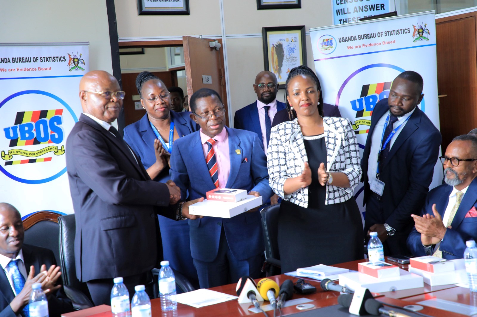 Dr. Chris Mukiza (L) hands over the donation to Prof. Buyinza Mukadasi (2nd L) as UBOS Board Director Dr. Allen Kabagenyi and other officials witness on 30th June 2025. Makerere University receiving 700 digital tablets from the Uganda Bureau of Statistics (UBOS), aimed at enhancing statistical research, teaching, and data-driven decision-making across the institution, 30th June 2025, Kampala Uganda, East Africa.