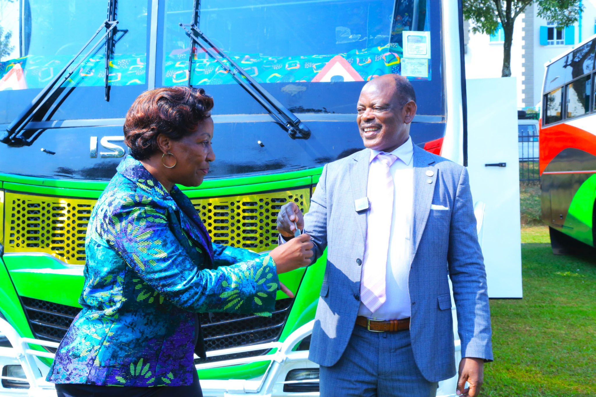 The Vice Chancellor, Prof. Barnabas Nawangwe (Right) handing over keys of branded buses to Prof. Gorettie N. Nabanoga the Principal College of Agricultural and Environmental Science