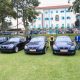 Officials stand besides five limousines recieved by Makerere University