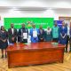 Vice Chancellor, Prof. Barnabas Nawangwe with Managing Director DFCU, Mr. Charles Mudiwaa holding the MoU in witness of other officials