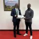 The Vice Chancellor, Prof. Barnabas Nawangwe (L) handing a gift to the Guild President from the University of South Africa (R) during their benchmarking at Makerere University.