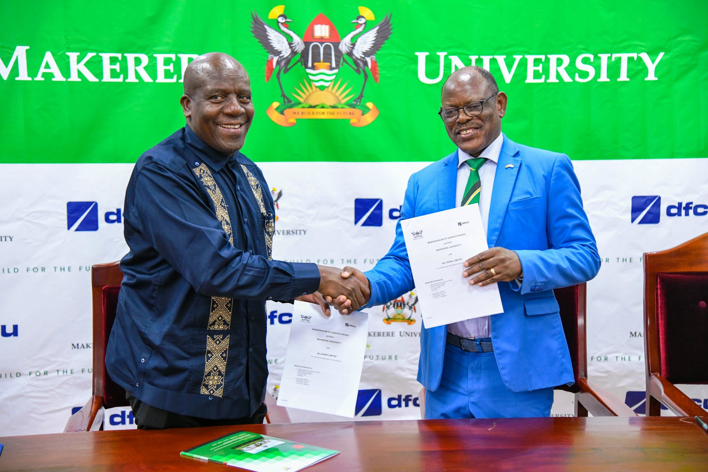 The Vice Chancellor-Prof. Barnabas Nawangwe (R) and MD DFCU Bank-Mr. Charles Mudiwa (L) shake hands after exchanging the signed MoU on 4th July 2025. Makerere University and DFCU Bank Limited sign a three-year Memorandum of Understanding (MoU) designed to enhance academic excellence, advance research and innovation capabilities, and provide crucial student support services through key activities; Annual Tumusiime Muteile Lecture, MakRun and Student activities, 4th July 2025, Council Room, Main Building, Makerere University, Kampala Uganda, East Africa.