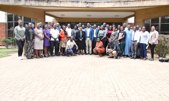 Director Prof. Julius Kikooma flanked by Prof. Christopher Mugimu in a group photo with doctoral students.