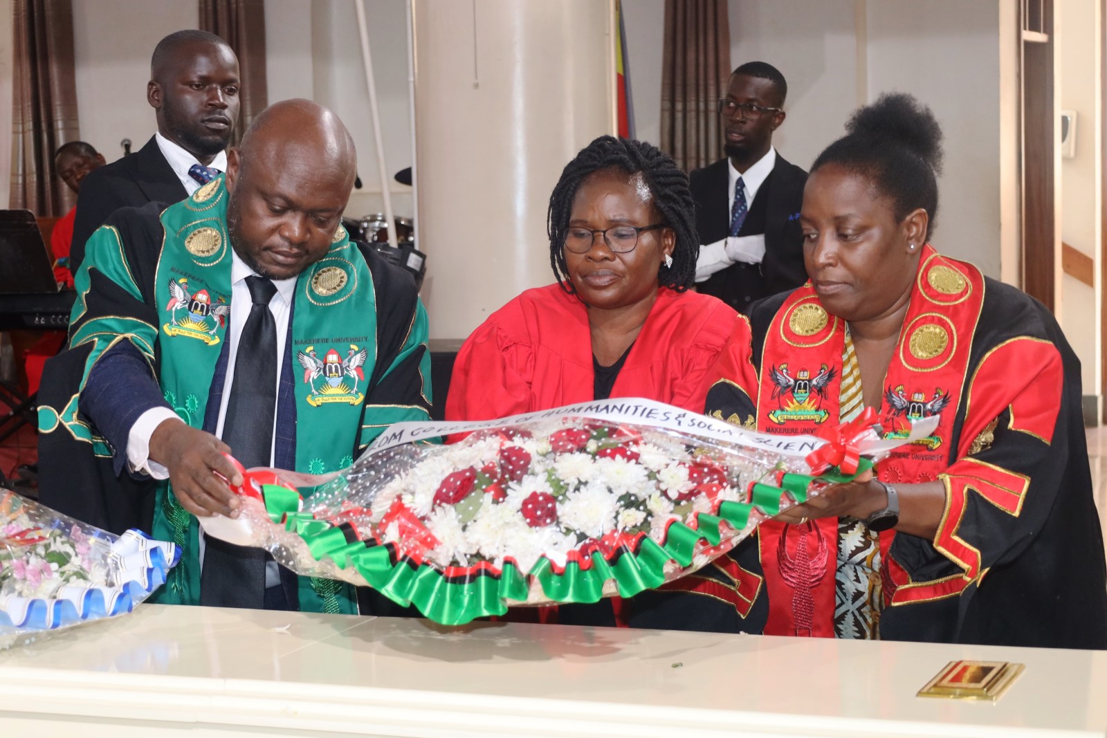 Prof. Helen Nambalirwa Nkabala (Right) is joined by Dr. Eric Awich Ochen (Left) and Dr. Eve Nabulya to lay a wreath on Dr. Brian Semujju's casket. Funeral service in honour of Dr. Brian Semujju-Senior Lecturer, Department of Journalism and Communication, School of Languages Literature and Communication, College of Humanities and Social Sciences (CHUSS), 5th August 2025, St. Francis Chapel, Makerere University, Kampala Uganda, East Africa.