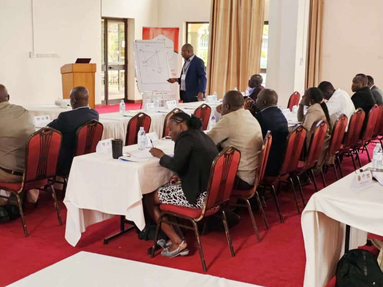 A section of participants listen to Dr. Kagarura. Public Investment Management Centre of Excellence (PIM CoE), Makerere University, Kampala, Ministry of Finance, Planning and Economic Development (MoFPED) and Cambridge Resources International (CRI), two-week intensive training on Economic Appraisal and Stakeholder Analysis for public officers from MDAs in Fort Portal, August 18 to 29, 2025, Final Module of the Investment Appraisal and Risk Analysis (PIAR) II Course.