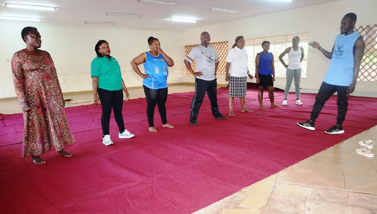 Participants follow instructions during a fitness and wellness session led by a trainer, as part of a health awareness initiative for staff at CoBAMS. Deputy Principal, Associate Professor James Wokadala launches College of Business and Management Sciences (CoBAMS) physical fitness program to promote wellness, better health, team work and cohesion, 17th July 2025, Makerere University, Kampala Uganda, East Africa.