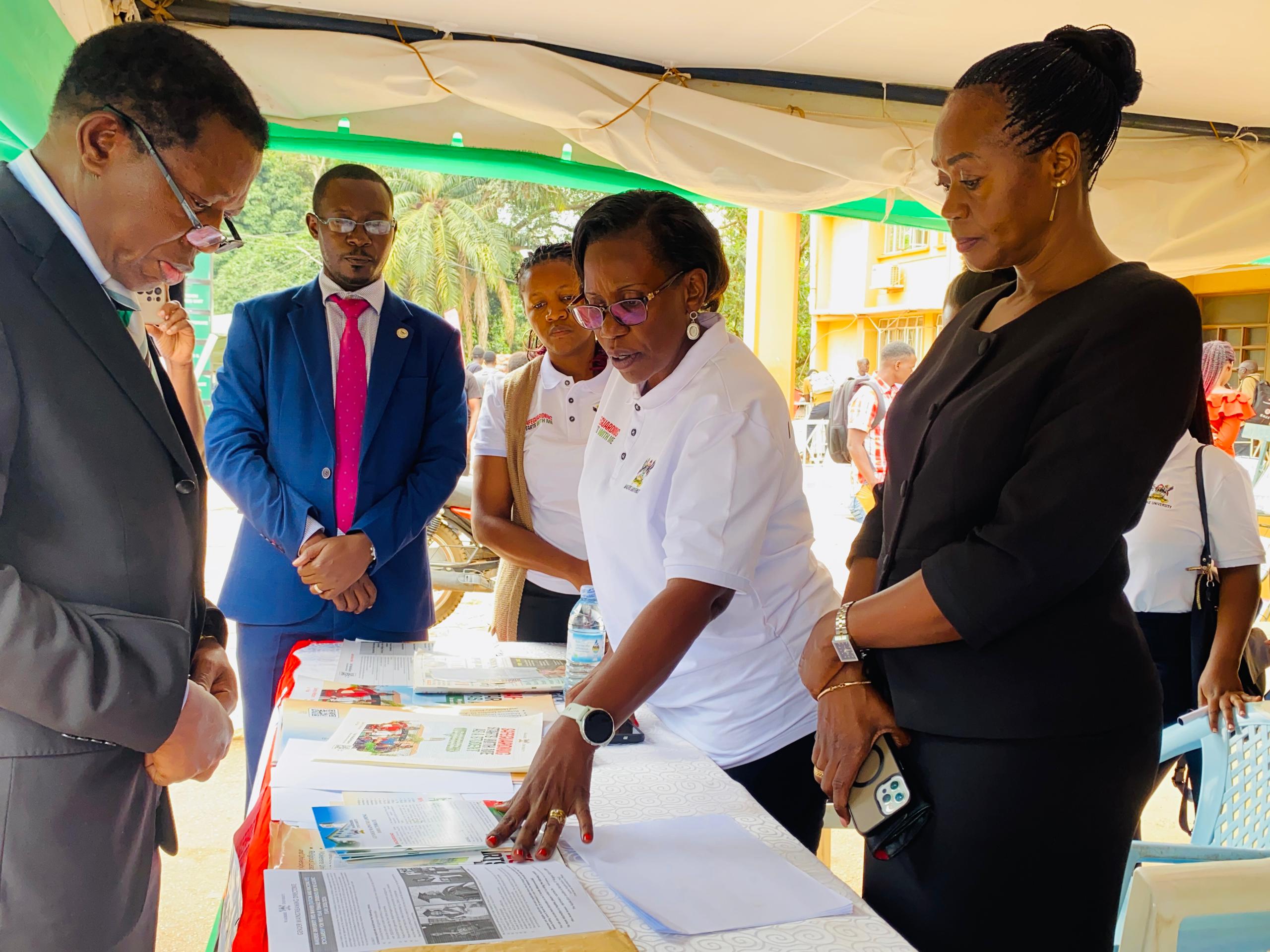 Prof. Buyinza Mukadasi (Left) is shown some of the informational materials. Intensive refresher training on Safeguarding for 25 Staff and 68 Student Safeguarding Champions key emphasis on increasing awareness of Safety and Well-being, 4th to 8th August 2025, Senate Conference Hall, Senate Building, Kampala Uganda, East Africa.