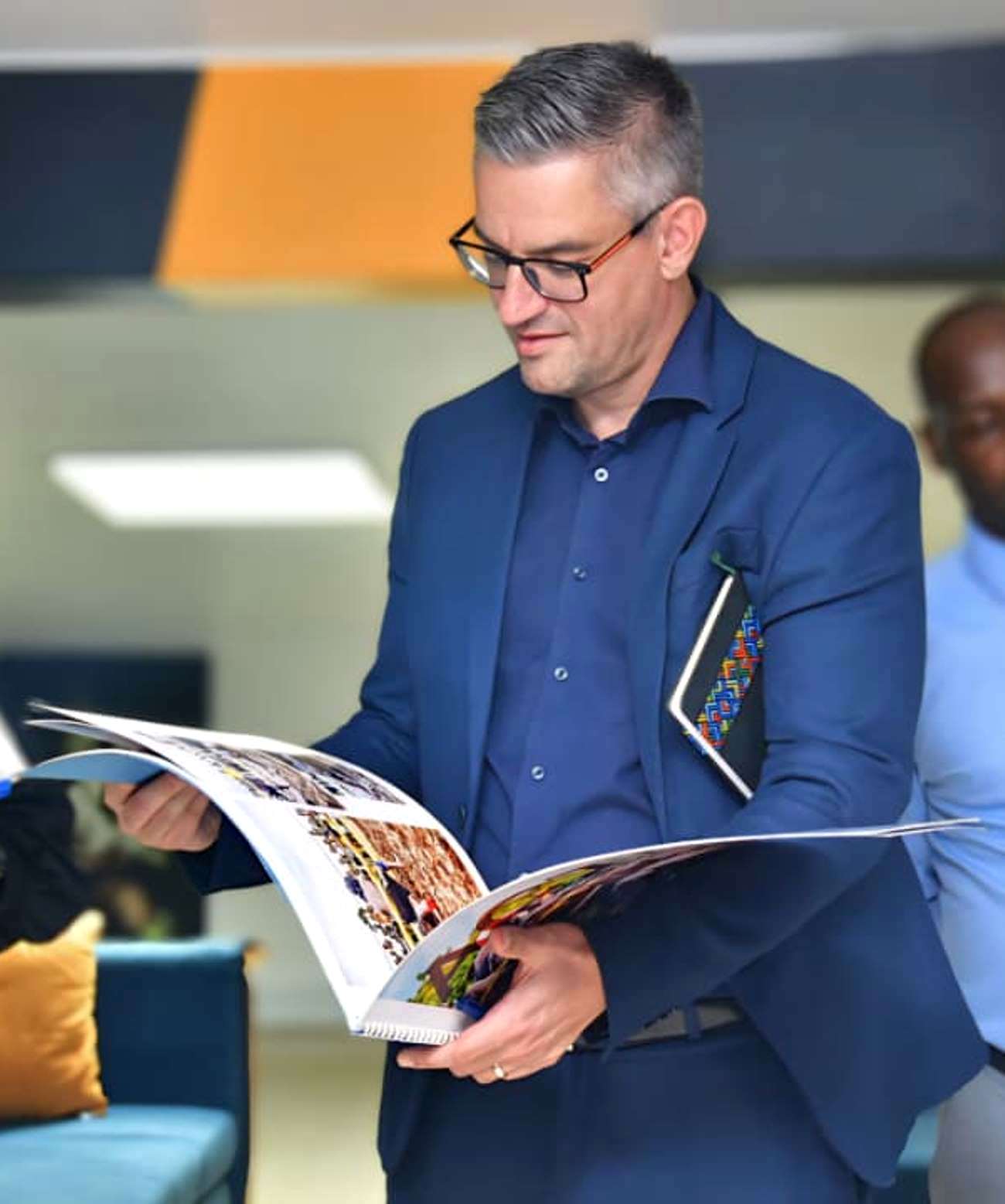 A representative from ENABEL admires a photo book produced by a Mak UniPod intern on Soft Ground Wrestling in Uganda. Delegation from the Belgian Embassy in Uganda, accompanied by representatives from ENABEL and the United Nations Development Programme (UNDP) visit to the Makerere University Innovation Pod (Mak UniPod), 1st September 2025, Kampala, East Africa.