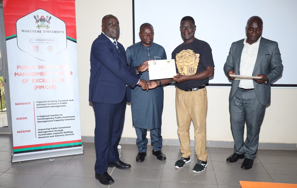 A male participant receives his certificate. Ministry of Finance, Planning and Economic Development (MoFPED), in partnership with the Public Investment Management Centre of Excellence (PIM CoE), Makerere University, Kampala, successful completion of two-week intensive training in the Certificate of Financial Implications (CFI) – Integrated Regulatory Cost-Benefit Analysis. September 5 2025, Pearl on the Nile Hotel, Jinja, Uganda, East Africa.