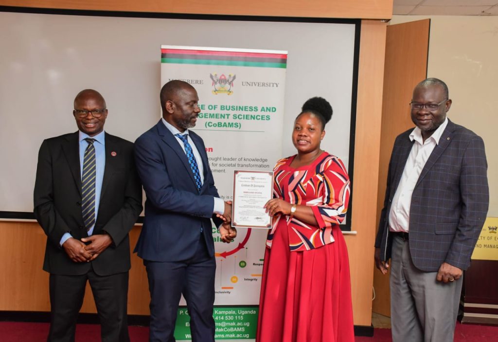 Prof. Kikooma presents a certificate to one of the participants.