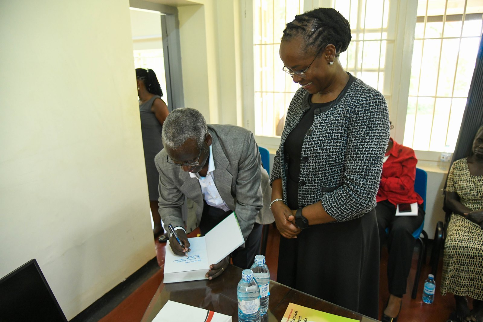 Dr. William Tayeebwa (R) autographs a copy of the Centennial Publication "Makerere's Century of Service to East Africa and Beyond" for Prof. Sarah Ssali (Right). First Deputy Vice Chancellor in charge of Academic Affairs, Prof. Sarah Ssali visits Makerere University Press (MakPress), which she visited today on 21st of October 2025, Kampala Uganda, East Africa.
