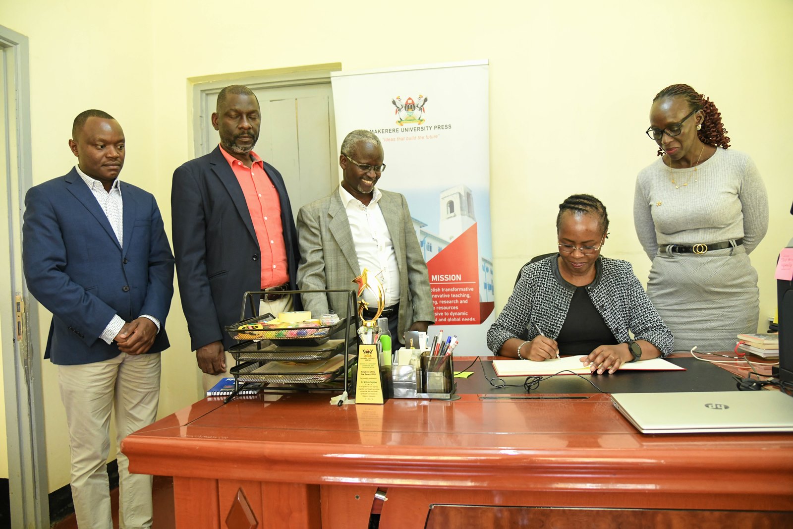 Prof. Sarah Ssali (2nd Right) flanked by Left-Right: Mr. Matthias Ssemanda, Prof. Julius Kikooma, Dr. William Tayeebwa and Ms. Eunice Rukundo signs the MakPress Visitors' Book. First Deputy Vice Chancellor in charge of Academic Affairs, Prof. Sarah Ssali visits Makerere University Press (MakPress), which she visited today on 21st of October 2025, Kampala Uganda, East Africa.