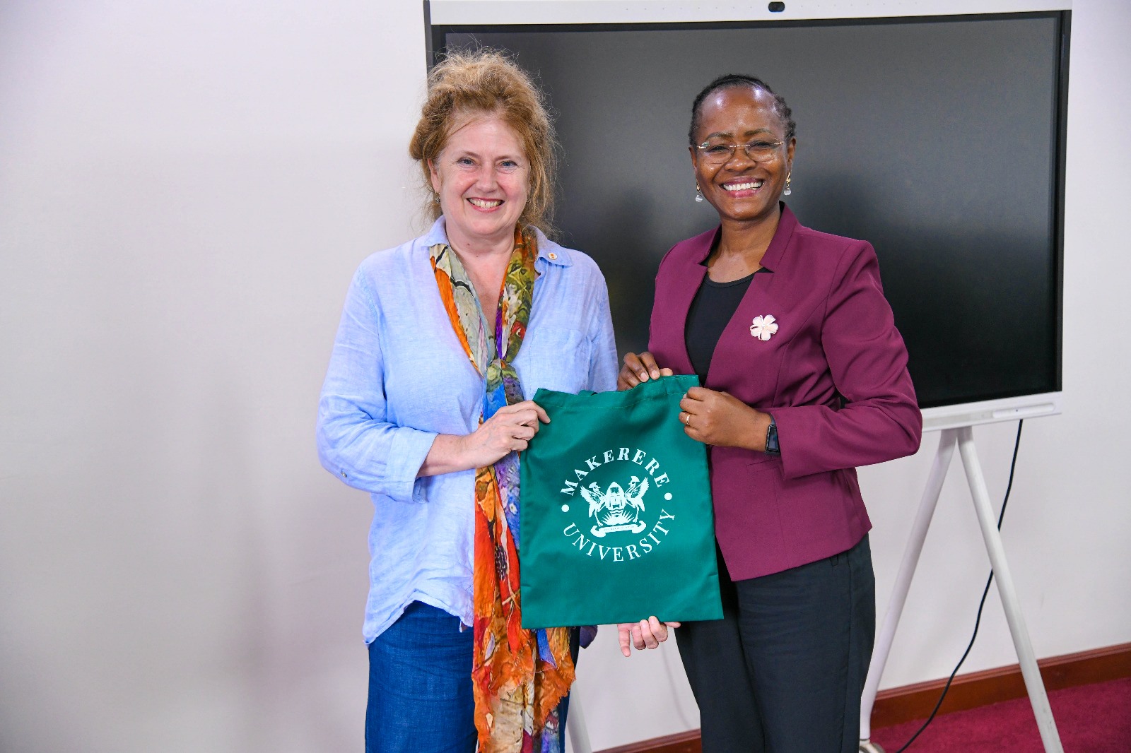 Prof. Sarah Ssali (R) presents a Mak Souvenir to Dr. Anita Veltmaat. Strategic meeting between Makerere University and the University of Groningen, Netherlands to move beyond existing collaborations and formalize a new Double Doctorate (PhD) program, 7th October 2025, Main Building, Kampala Uganda, East Africa.